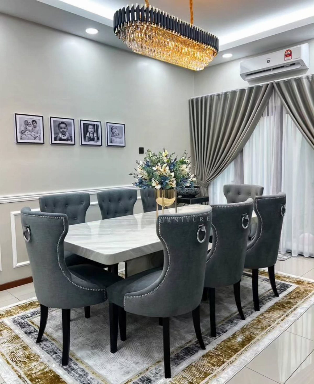 White marble dining table with six grey upholstered chairs in a modern room.