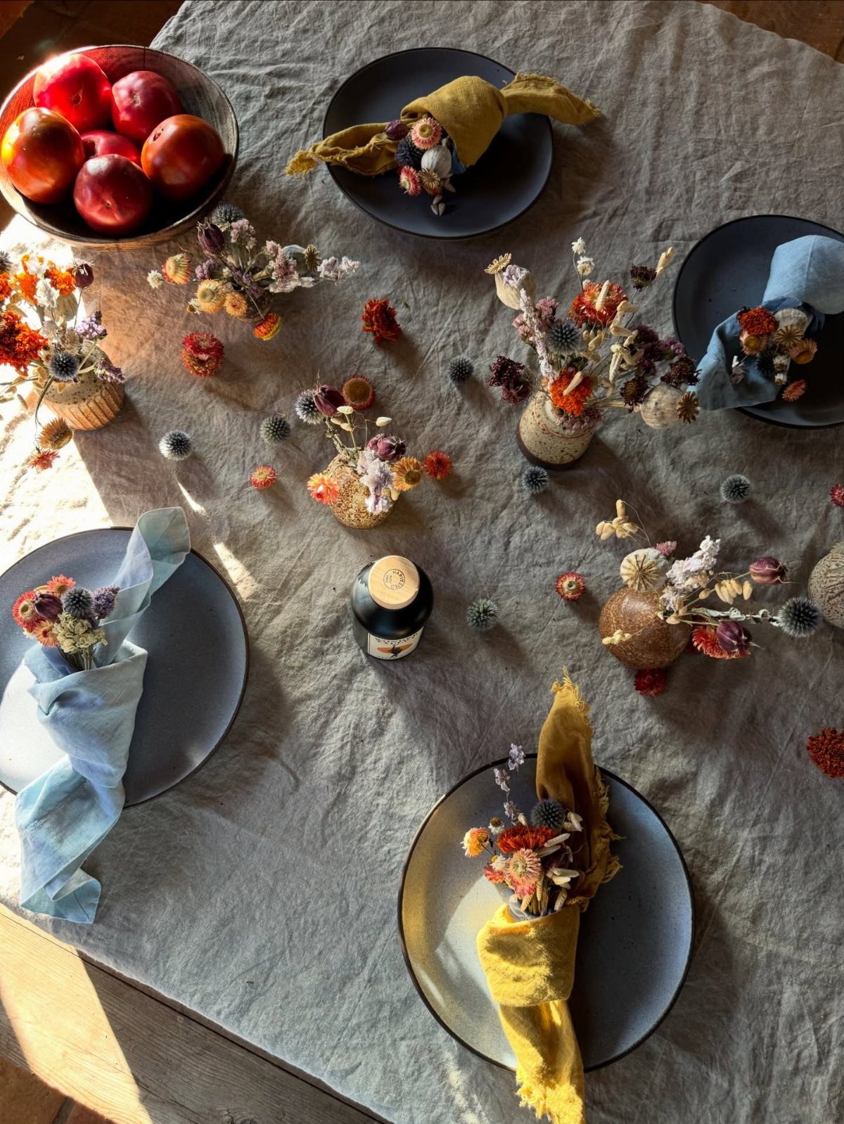 18 Autumn Dining Room Decor Ideas for a Warm and Inviting Space 10 Dining table set with grey linen, red apples, and dried grass arrangements.