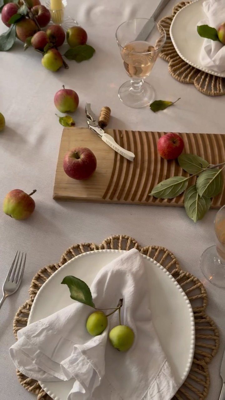 18 Autumn Dining Room Decor Ideas for a Warm and Inviting Space 1 Red and green apples scattered on a light tablecloth with white plates and napkins.