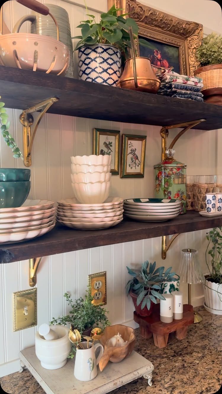 12 Bohemian Chic Dining Room Ideas for Effortless Style 8 Dark wooden open shelves with gold brackets holding ceramic dishes and indoor plants.