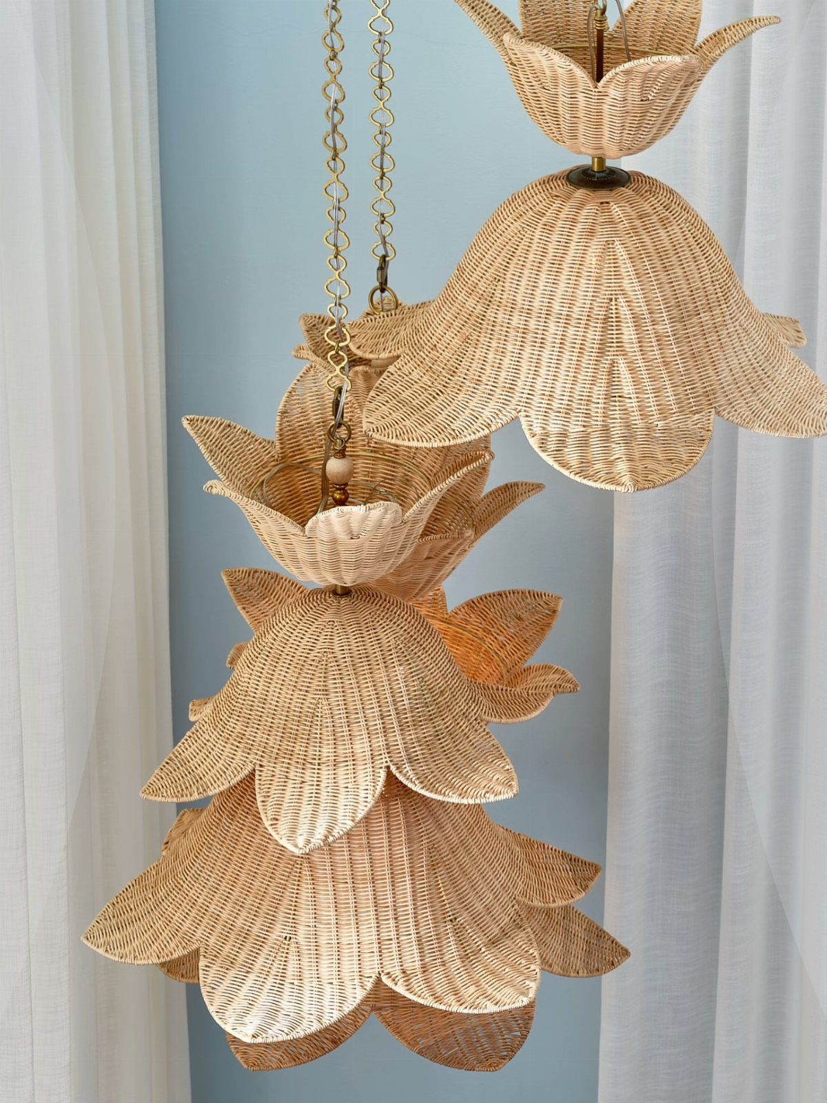 12 Bohemian Chic Dining Room Ideas for Effortless Style 5 Woven rattan pendant lights shaped like tiered flowers hanging from gold chains.