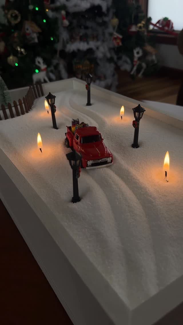 21 Christmas Decor Gift Ideas for the Holidays 20 Miniature red truck in a snowy scene with glowing lampposts and Christmas tree.