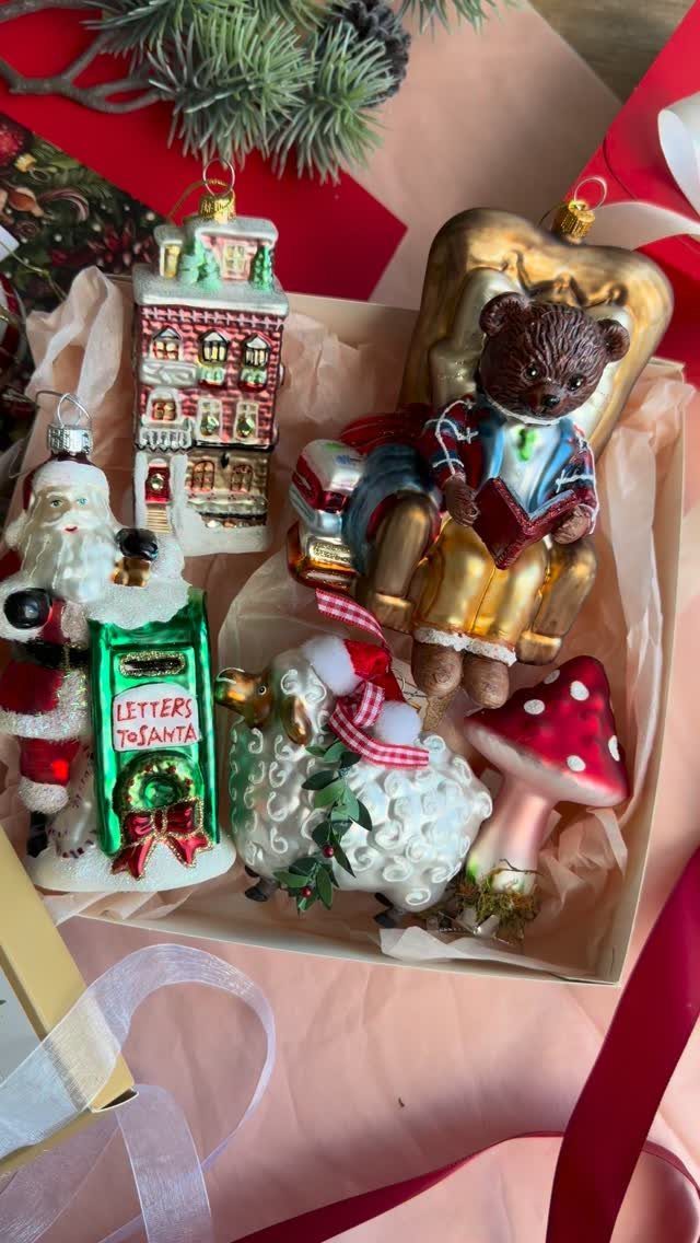 21 Christmas Decor Gift Ideas for the Holidays 17 Christmas ornaments in a gift box with pink tissue paper and red ribbons.