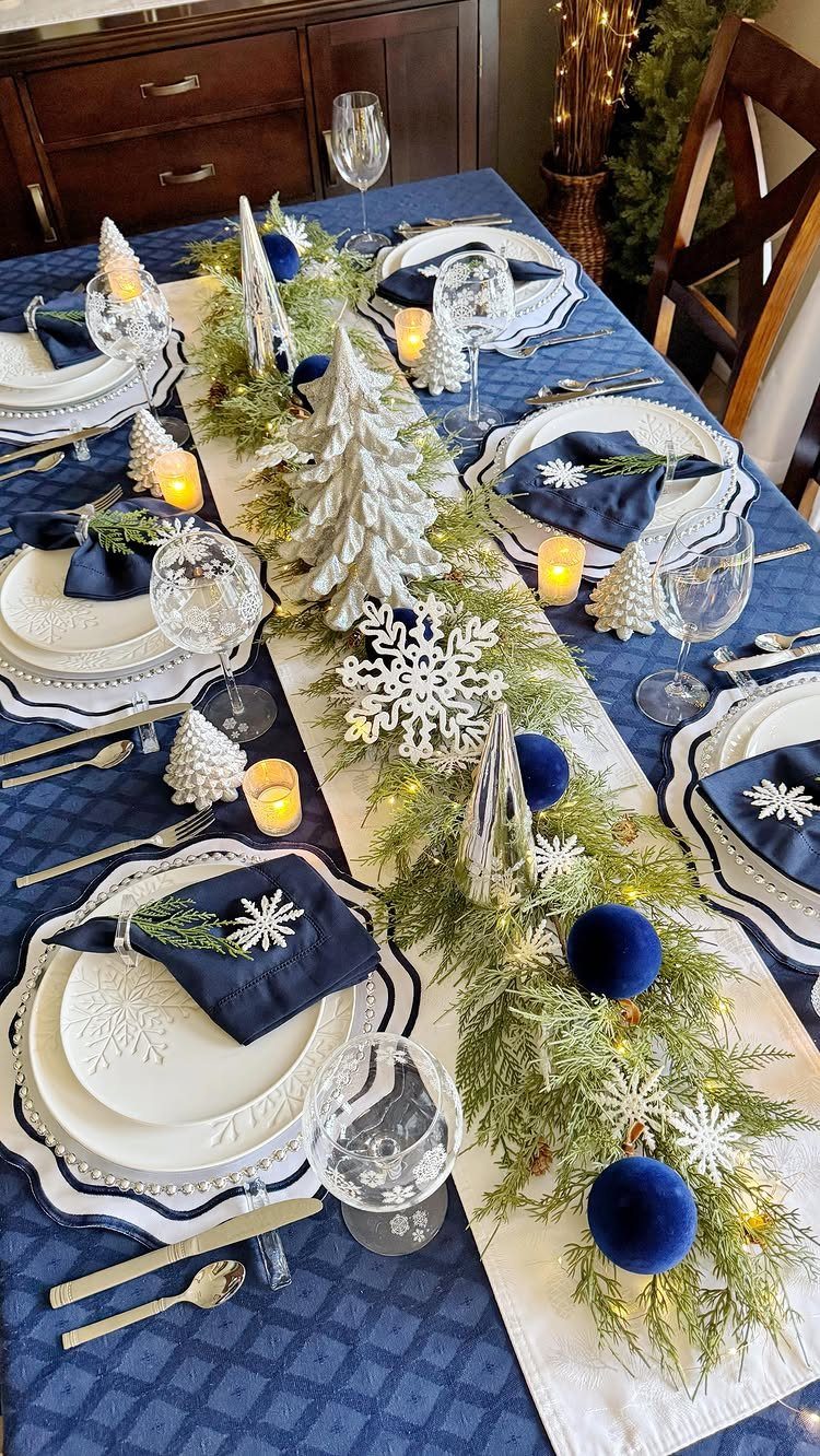 17 Christmas Decor Ideas with White for a Serene Home 7 Dining table set with white plates, blue napkins, and a festive white and blue centerpiece.