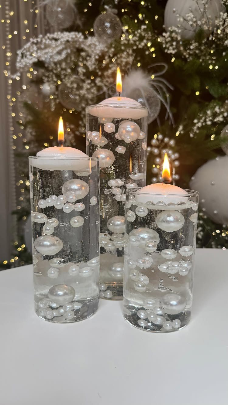 17 Christmas Decor Ideas with White for a Serene Home 16 Floating white candles in glass vases with white pearls before a decorated Christmas tree