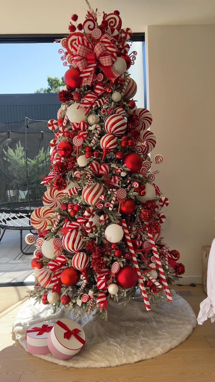 Christmas tree decorated with red and white candy cane ornaments and peppermint swirls.
