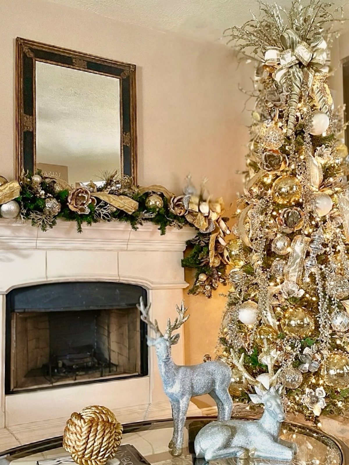 Gold and silver Christmas tree next to a decorated white fireplace mantel.