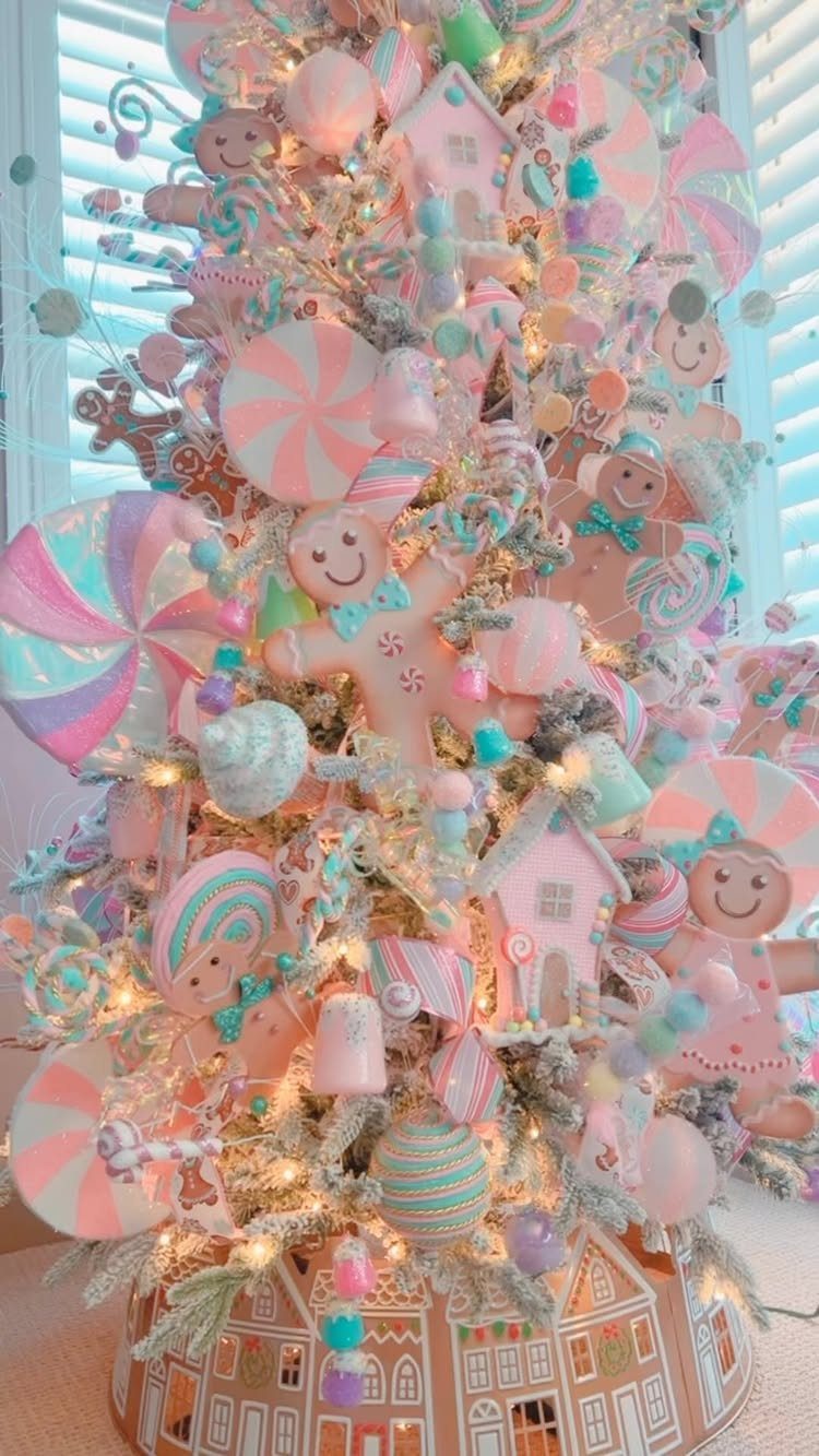 Pastel Christmas tree decorated with pink and blue candy ornaments and gingerbread figures.