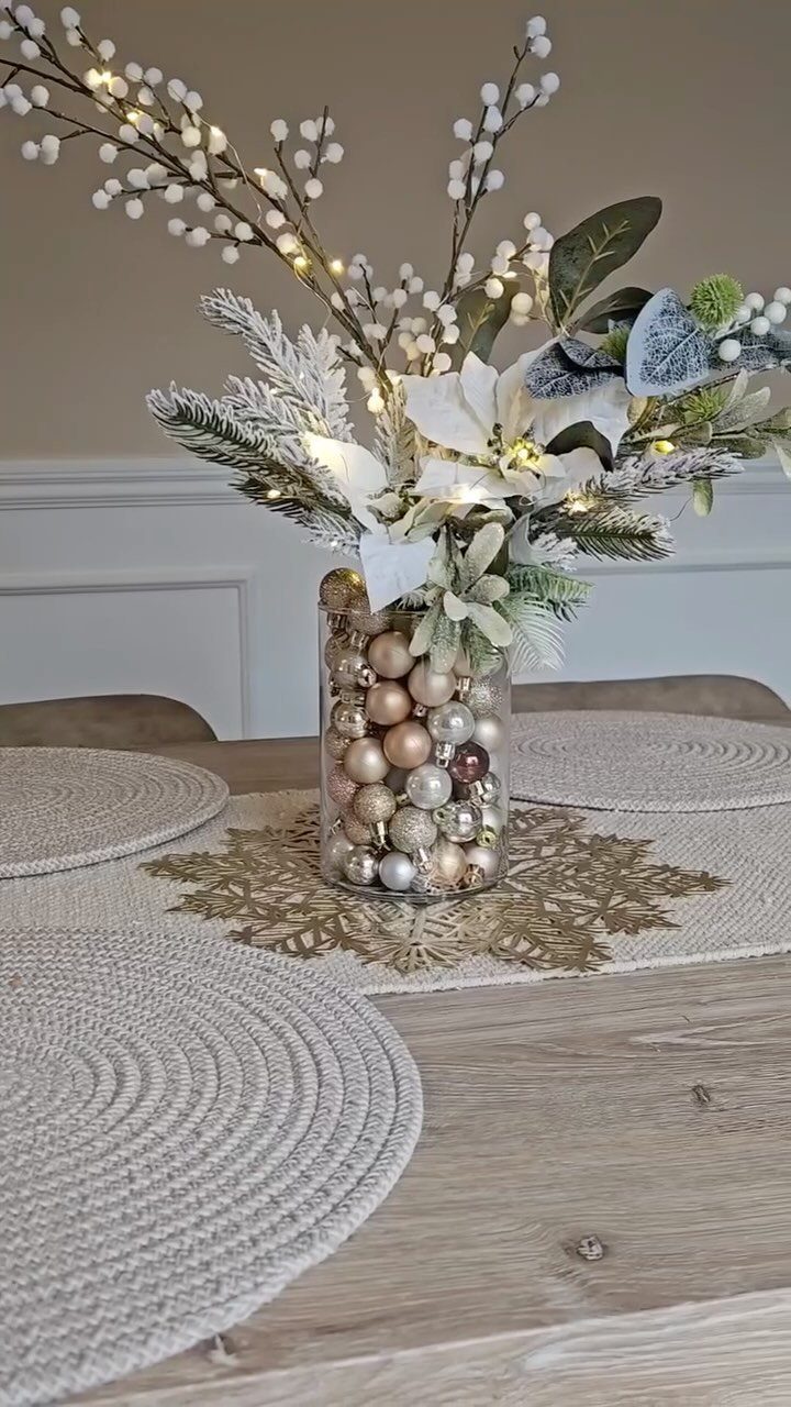 20 Christmas Decorations to Make at Home in 2026 20 Winter floral arrangement in a bauble-filled vase on a wooden dining table