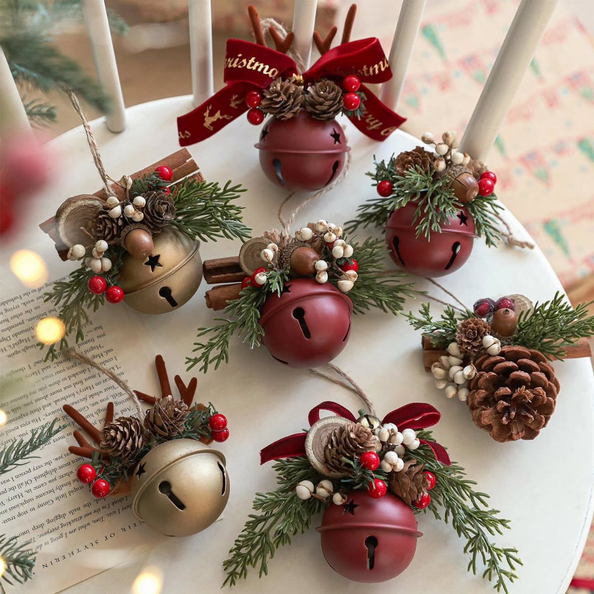 20 Christmas Decorations to Make at Home in 2026 19 Red and gold jingle bell ornaments decorated with pinecones and evergreen sprigs.