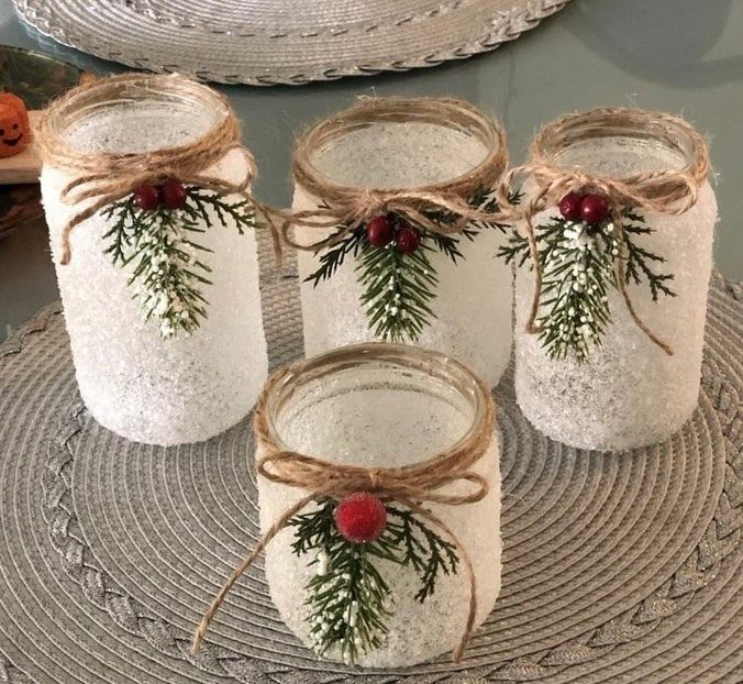 20 Christmas Decorations to Make at Home in 2026 11 Frosted white mason jars decorated with twine bows, evergreen sprigs, and red berries.