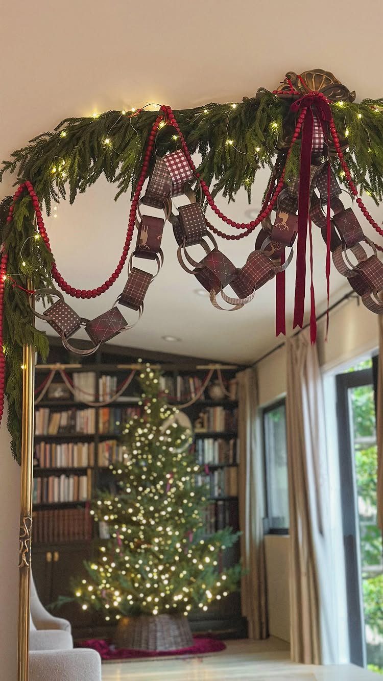 20 Christmas Decorations to Make at Home in 2026 1 Red checkered paper chain garlands draped over evergreen branches with fairy lights.