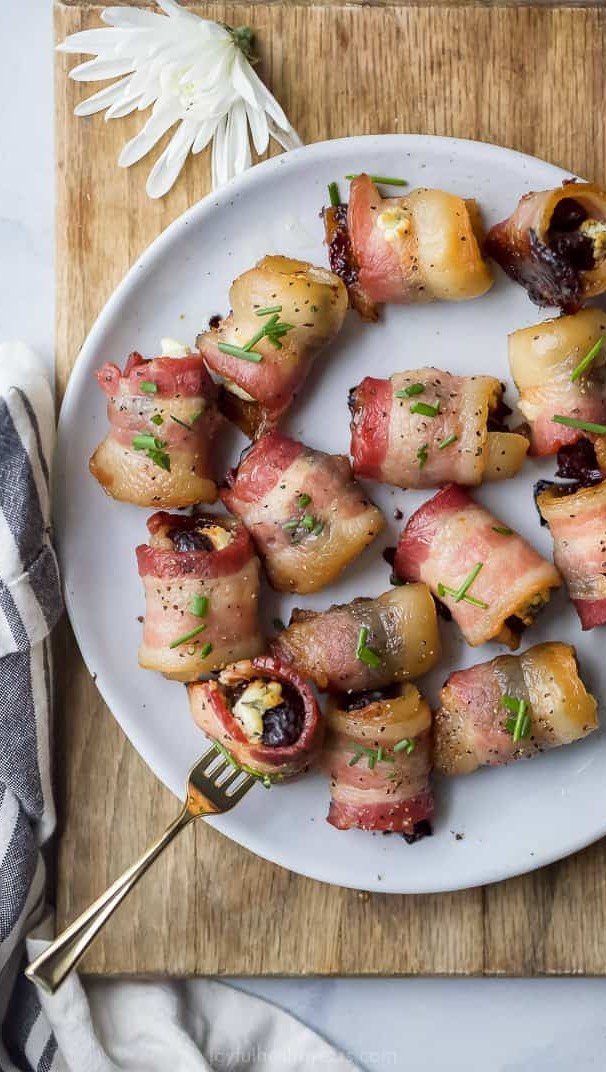 15 Christmas Dinner Party Ideas for a Festive Celebration 14 Bacon-wrapped water chestnuts with stuffing and chives on a grey plate.