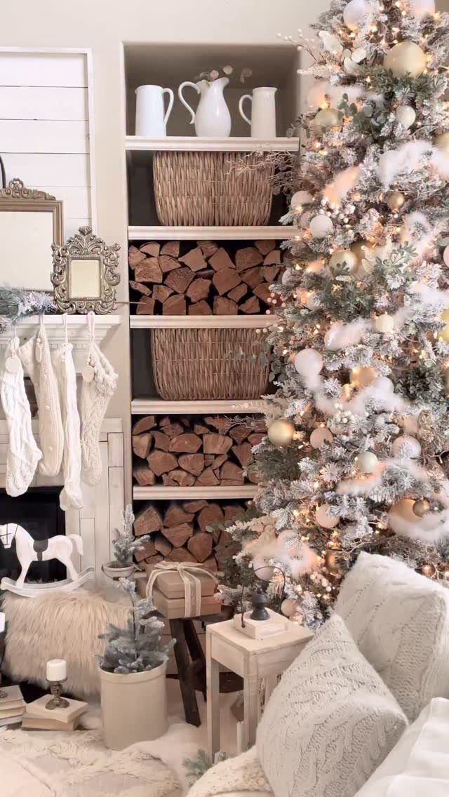 23 Christmas House Decorations Ideas for a Festive Home 4 Flocked Christmas tree and white stockings beside stacked firewood and plush white pillows.