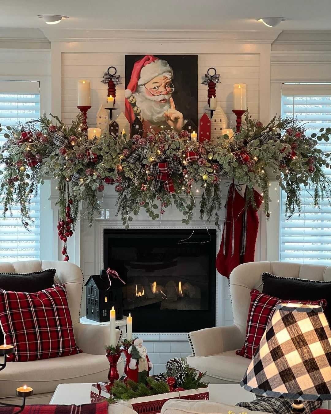 23 Christmas House Decorations Ideas for a Festive Home 13 Decorated white fireplace mantel with festive greenery, red accents, and a Santa portrait.