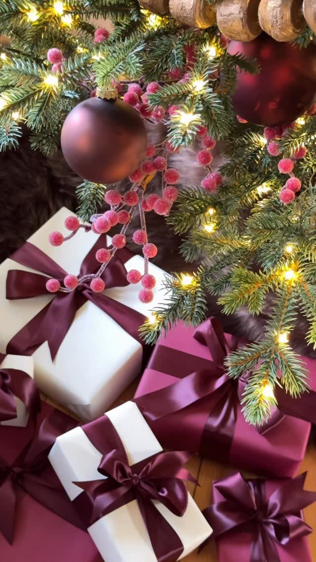 23 Christmas House Decorations Ideas for a Festive Home 3 Wrapped white and burgundy gift boxes under a lit Christmas tree branch.