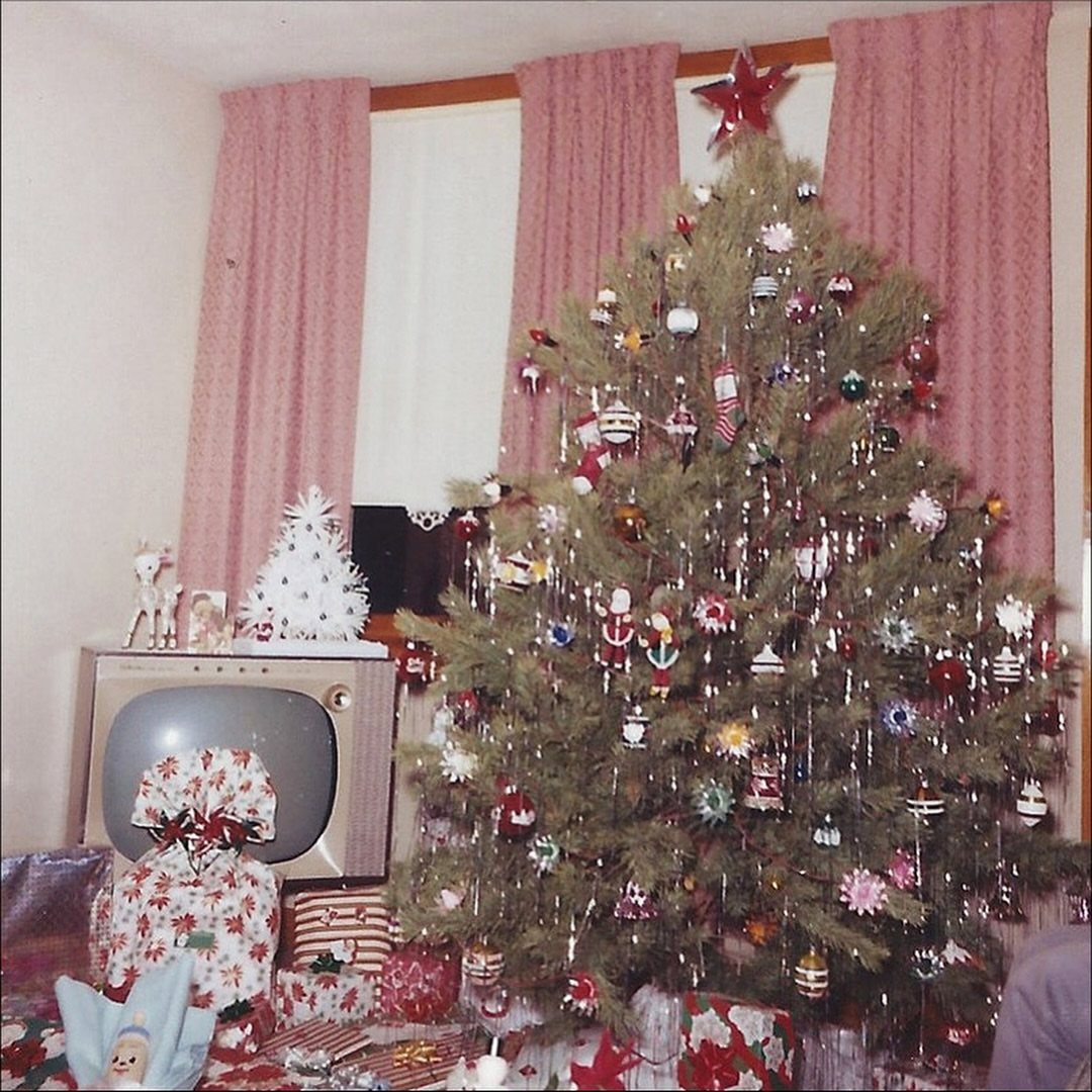 23 Christmas House Decorations Ideas for a Festive Home 18 Decorated Christmas tree and vintage television set with wrapped gifts and pink curtains.