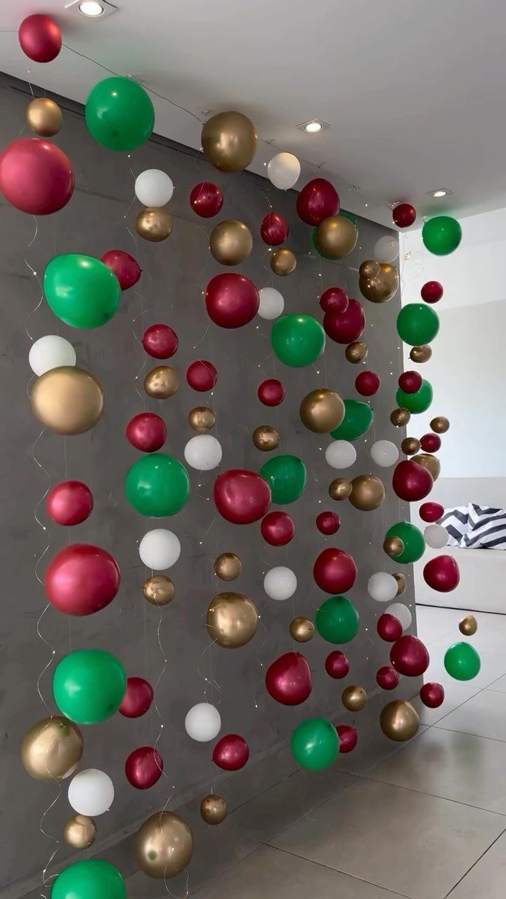 33 Christmas Party Decor Ideas to Bring the Holiday Magic 19 Red, green, gold, and white balloons floating against a grey interior wall.