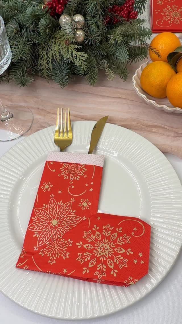 33 Christmas Party Decor Ideas to Bring the Holiday Magic 24 Red and gold patterned napkin folded as a stocking on a white plate