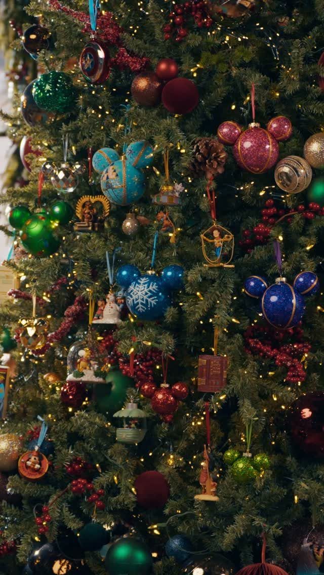 Christmas tree decorated with Mickey Mouse shaped ornaments and colorful festive baubles.