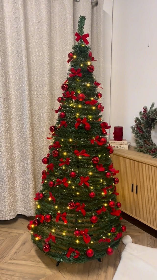 11 Christmas Tree Decorations with Ribbon Ideas 11 Christmas tree decorated with red bows and baubles and warm yellow fairy lights.