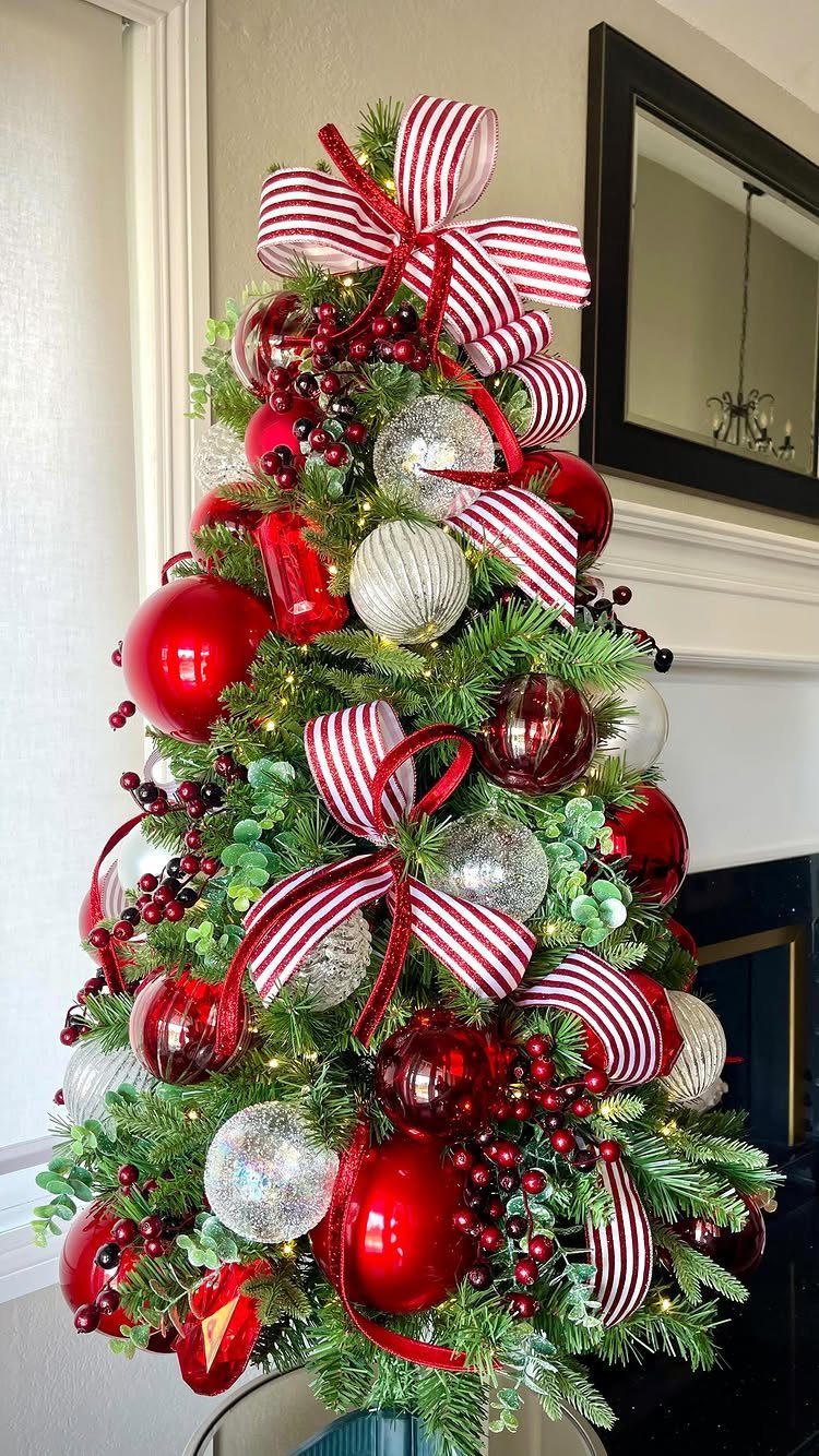 11 Christmas Tree Decorations with Ribbon Ideas 10 Christmas tree decorated with red and silver ornaments and red-and-white striped ribbons.