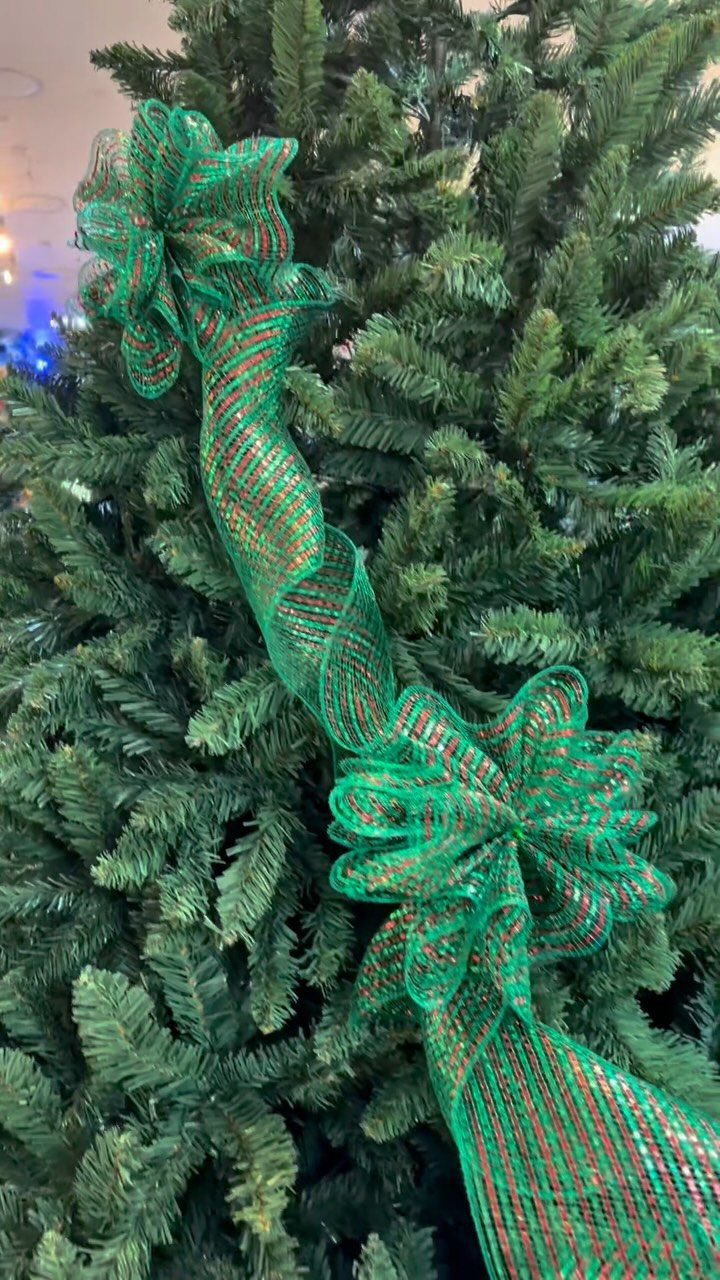 11 Christmas Tree Decorations with Ribbon Ideas 2 Green and red striped wired ribbon spiraling around a green Christmas tree with bows