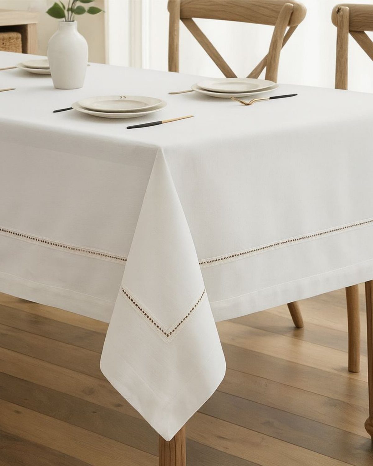 13 Contemporary Dining Room Decor Ideas for 2026 9 White linen tablecloth with gold trim on a wooden dining table with plates.