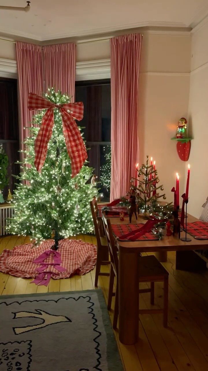 12 Cozy Christmas Living Room Ideas with Photos 6 Christmas tree with red checkered bow next to a dining table with red candles.