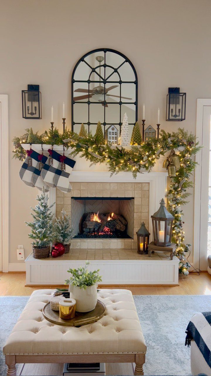 12 Cozy Christmas Living Room Ideas with Photos 7 Decorated white fireplace mantel with green garland, candles, and plaid Christmas stockings.