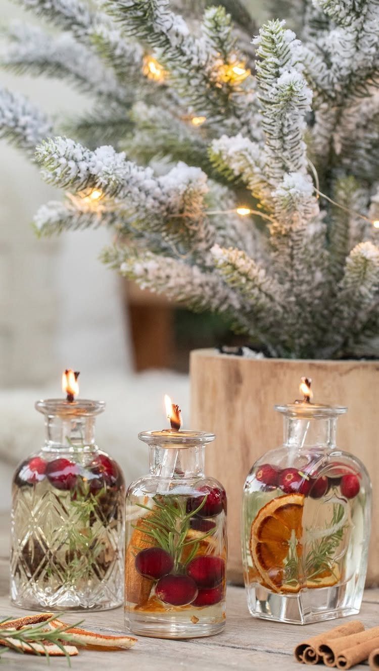 12 Cozy Christmas Living Room Ideas with Photos 11 Glass candleholders with cranberries and citrus slices beside a frosted Christmas tree branch.