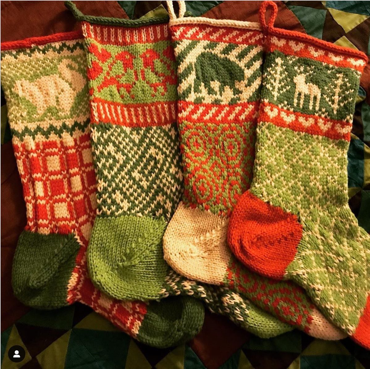 12 Cozy Christmas Living Room Ideas with Photos 8 Four knitted Christmas stockings in red and green patterns on a colorful quilt.