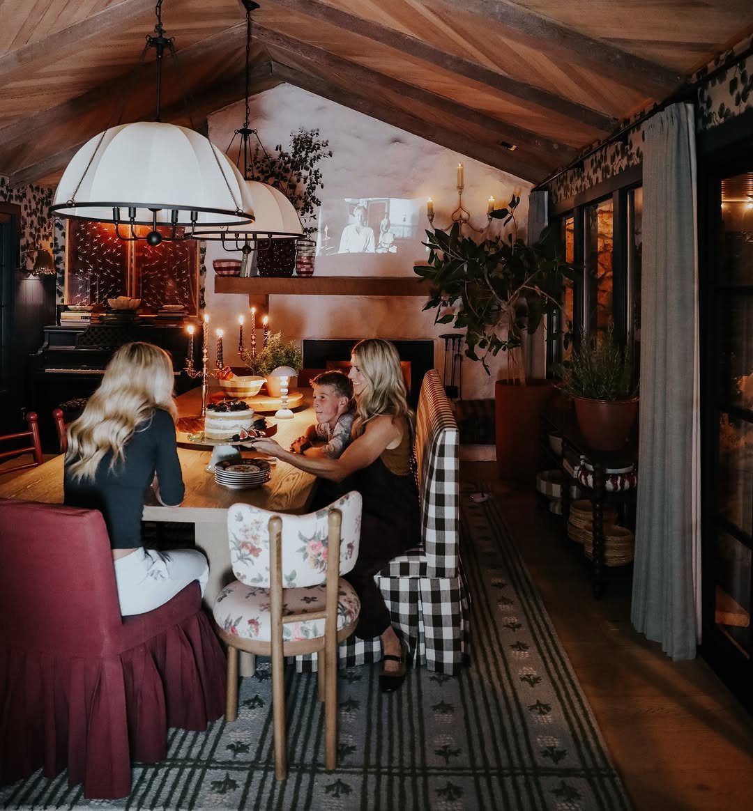 11 Dark Academia Dining Room Ideas for Moody Elegance 10 Dining room with wooden beams, candlelit table, and people in a moody setting.