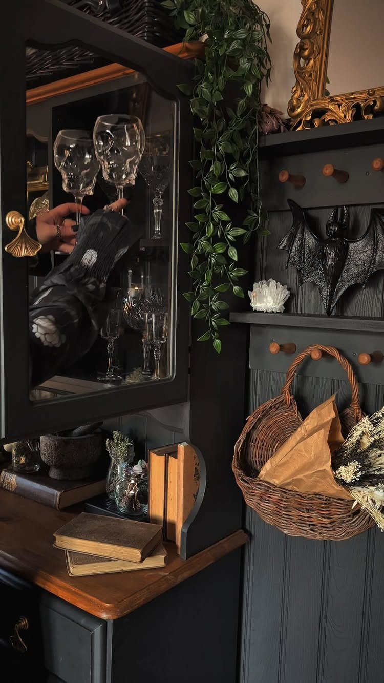 11 Dark Academia Dining Room Ideas for Moody Elegance 8 Dark grey hutch with skull glasses, old books, and gothic decor in moody lighting.