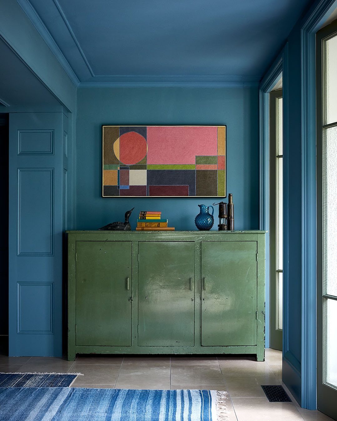 Dark blue room with matching walls and ceiling featuring a green vintage cabinet.