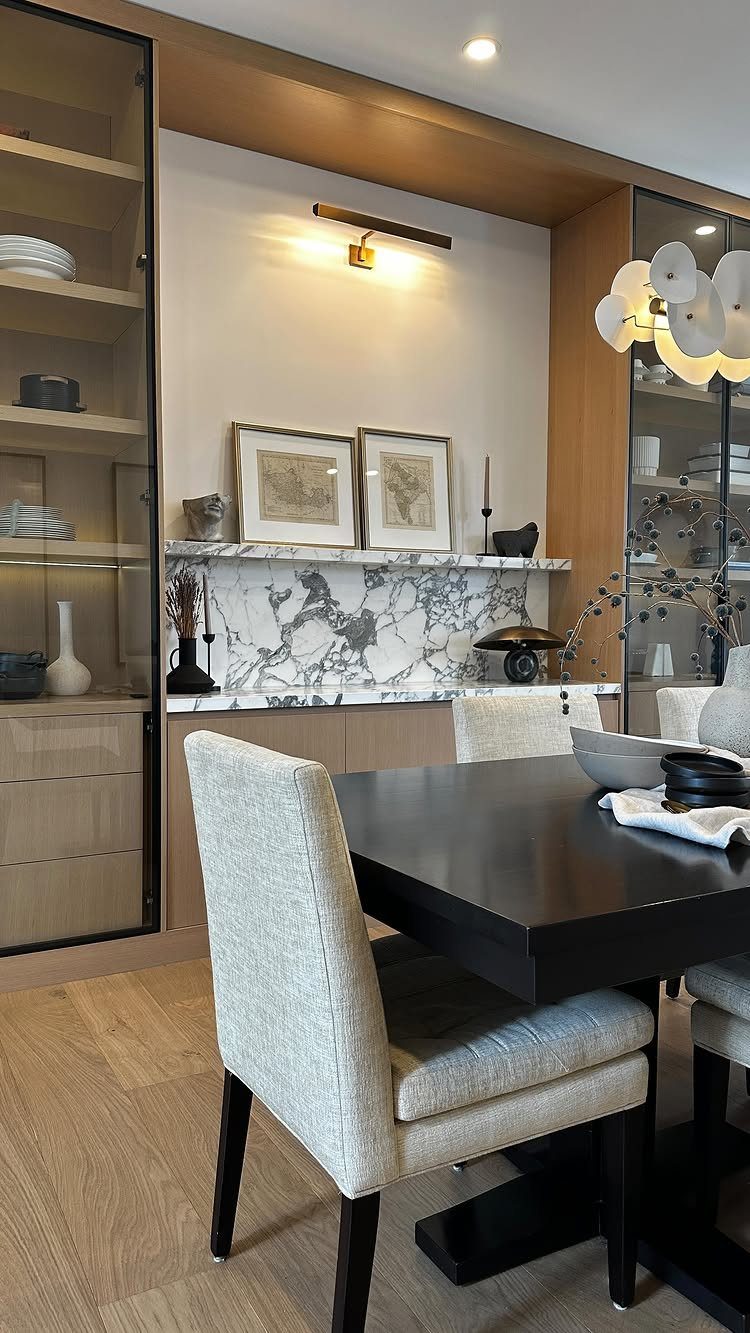 10 Ideas for Decorating a Dining Room Sideboard 9 Modern dining room with a decorated sideboard featuring marble and framed art.