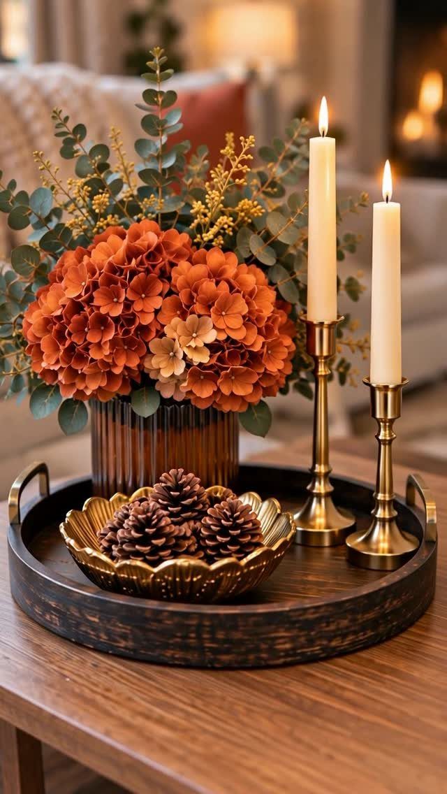 10 Ideas for Decorating a Dining Room Sideboard 1 Wooden tray holding orange flowers, lit taper candles, and pinecones on a table.