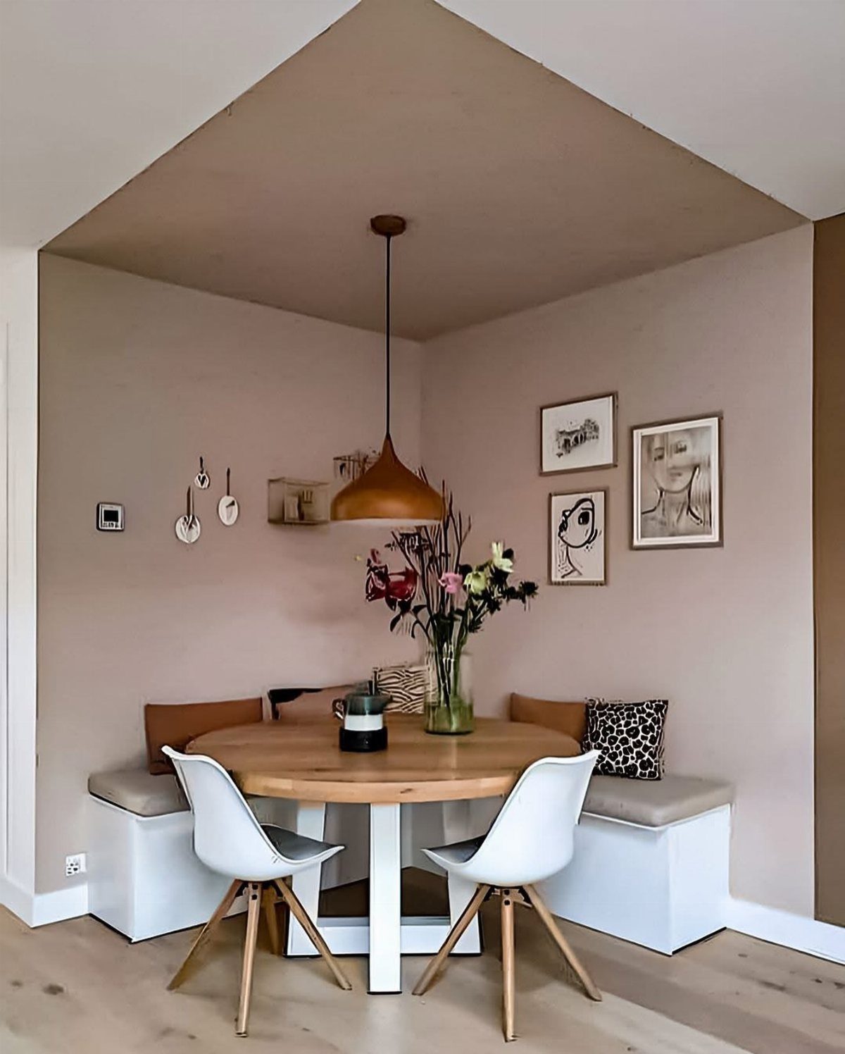 15 Dining Ideas for Small Spaces That Maximize Every Inch 13 Round wooden dining table with white chairs and built-in bench seating in nook