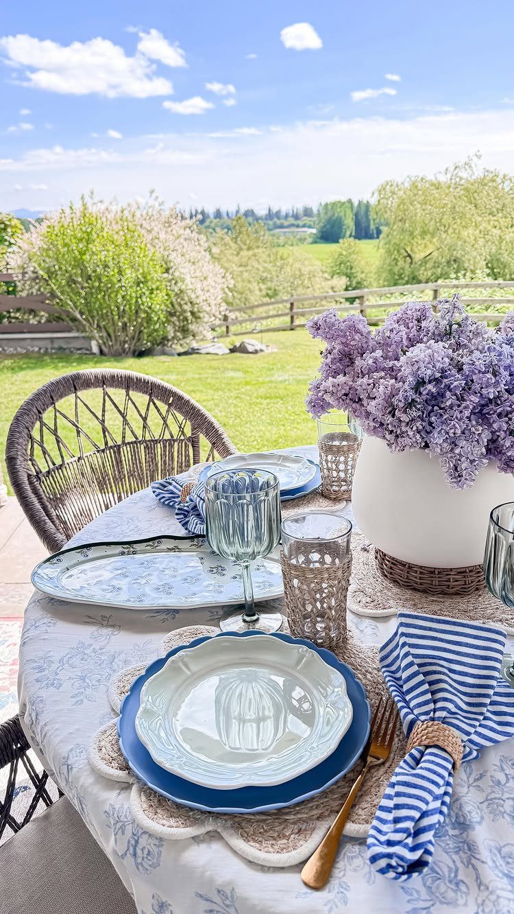 15 Dining Ideas for Small Spaces That Maximize Every Inch 11 Outdoor dining table set with blue and white patterned linens and purple lilacs.