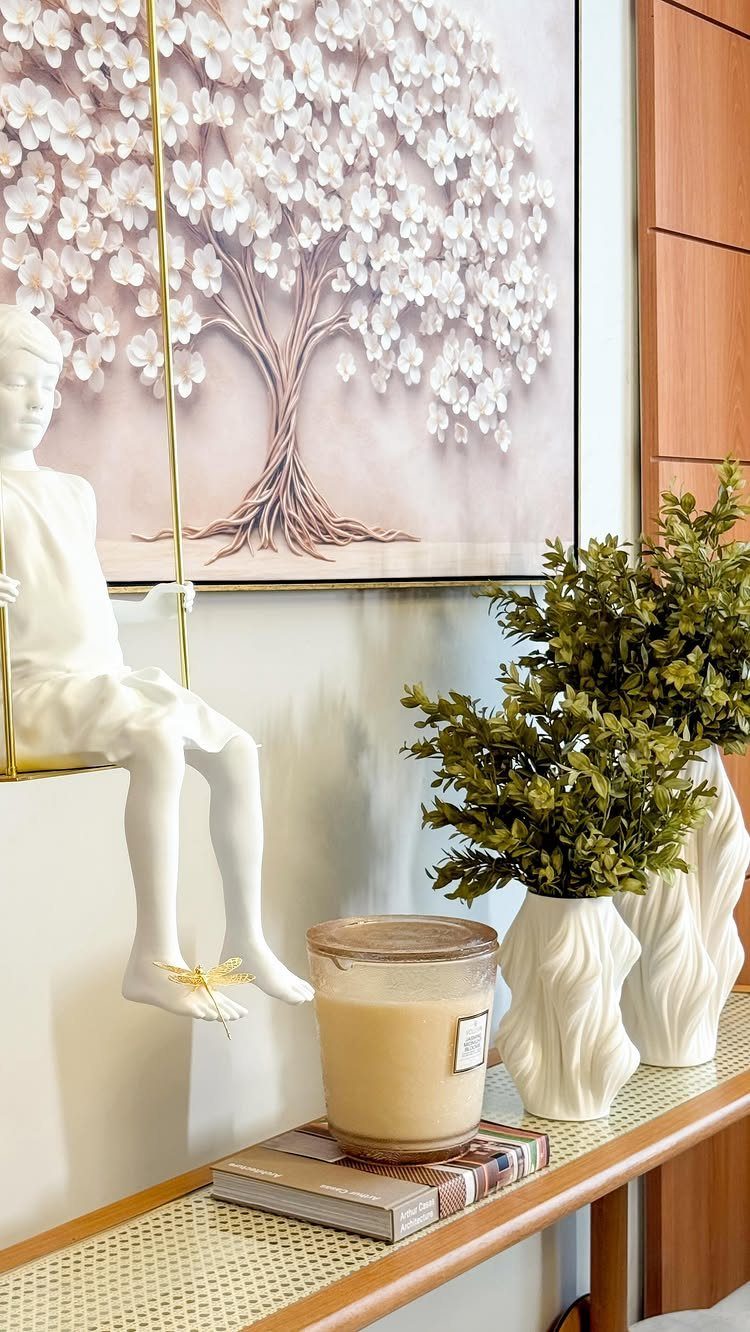 Buffet table decor with a candle, sculptural vases, and a child statue.