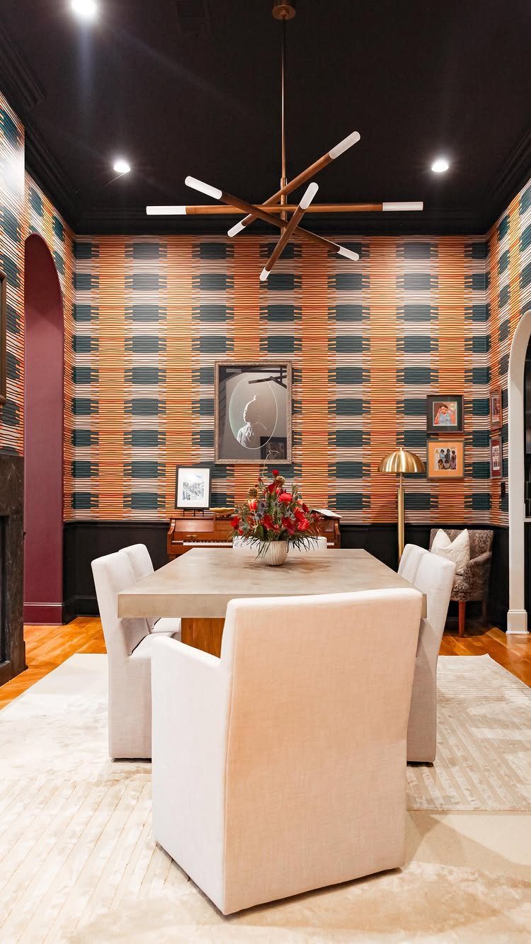 6 Dining Room Chair Rail Ideas for a Polished Look 4 Dining room with black lower walls, patterned wallpaper, and white upholstered chairs.