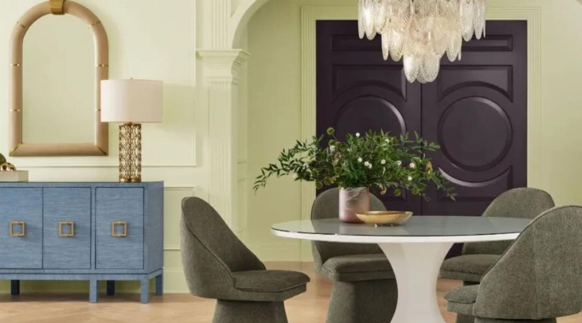 10 Dining Room Colors for 2027 That Feel Fresh and Grounded 5 Dining room with pale green walls, white table, grey chairs, and dark purple doors.