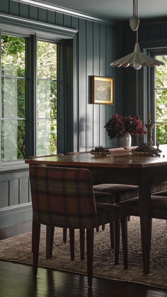 9 Dining Room Color Ideas for a Welcoming Space 1 Deep navy blue paneled dining room with wooden table and plaid chairs.