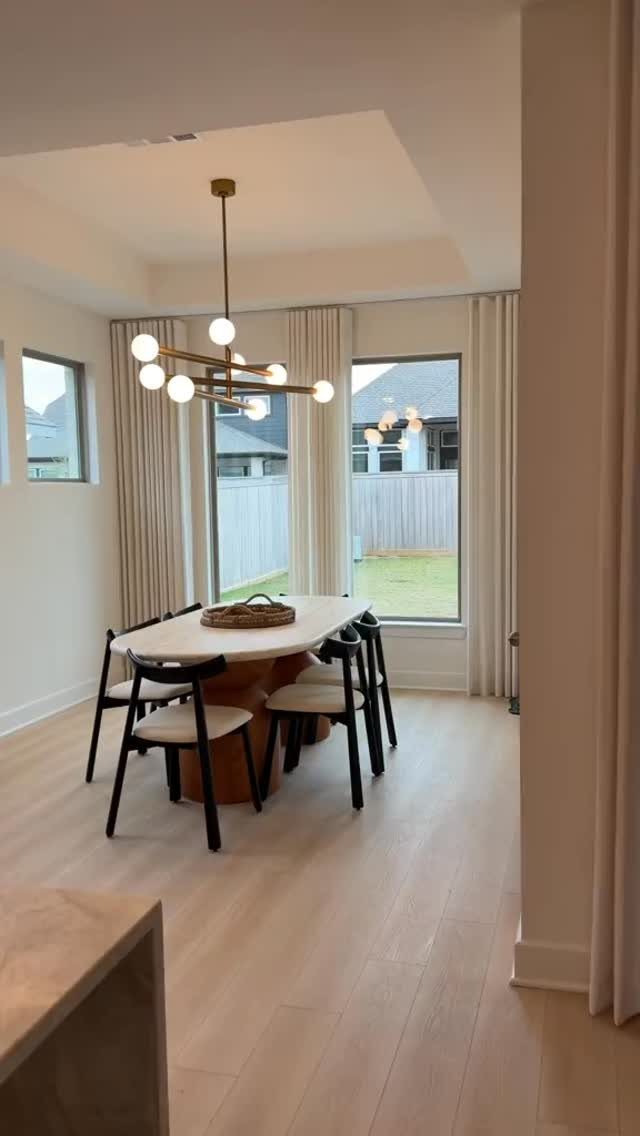 9 Dining Room Color Ideas for a Welcoming Space 4 Bright dining room with soft white walls, light wood floors, and modern gold lighting.