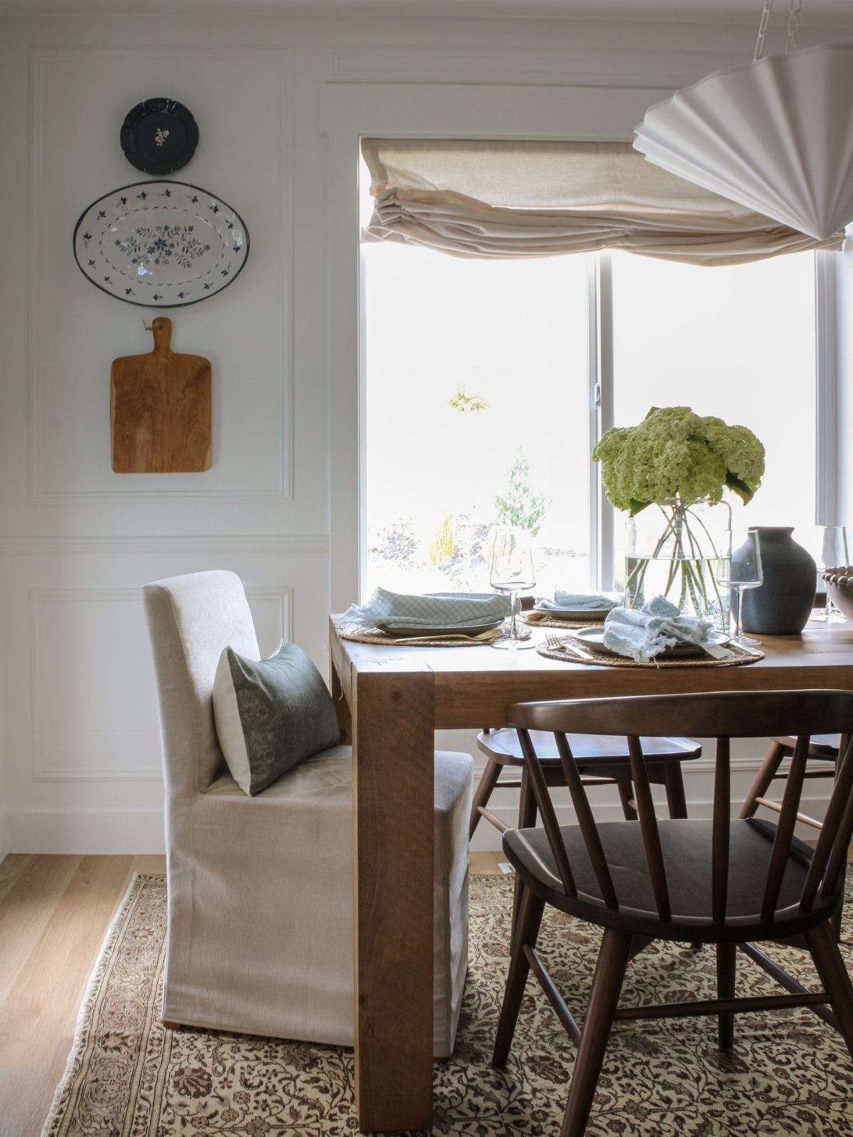 10 Dining Room Decorating Ideas for 2027 That Feel Fresh 6 Wooden dining table set for a meal with mixed chairs in a bright room.