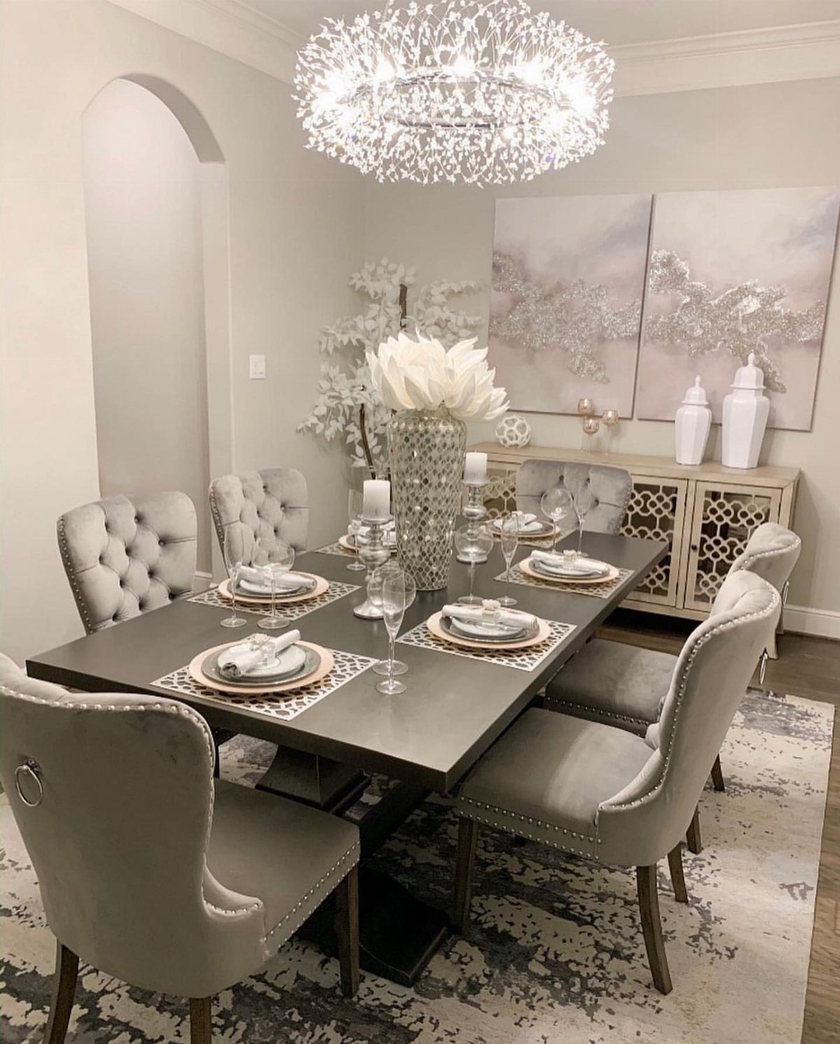 10 Dining Room Grey Wall Ideas for a Refined Look 6 Dining room with light grey walls, grey velvet chairs, and a crystal chandelier.