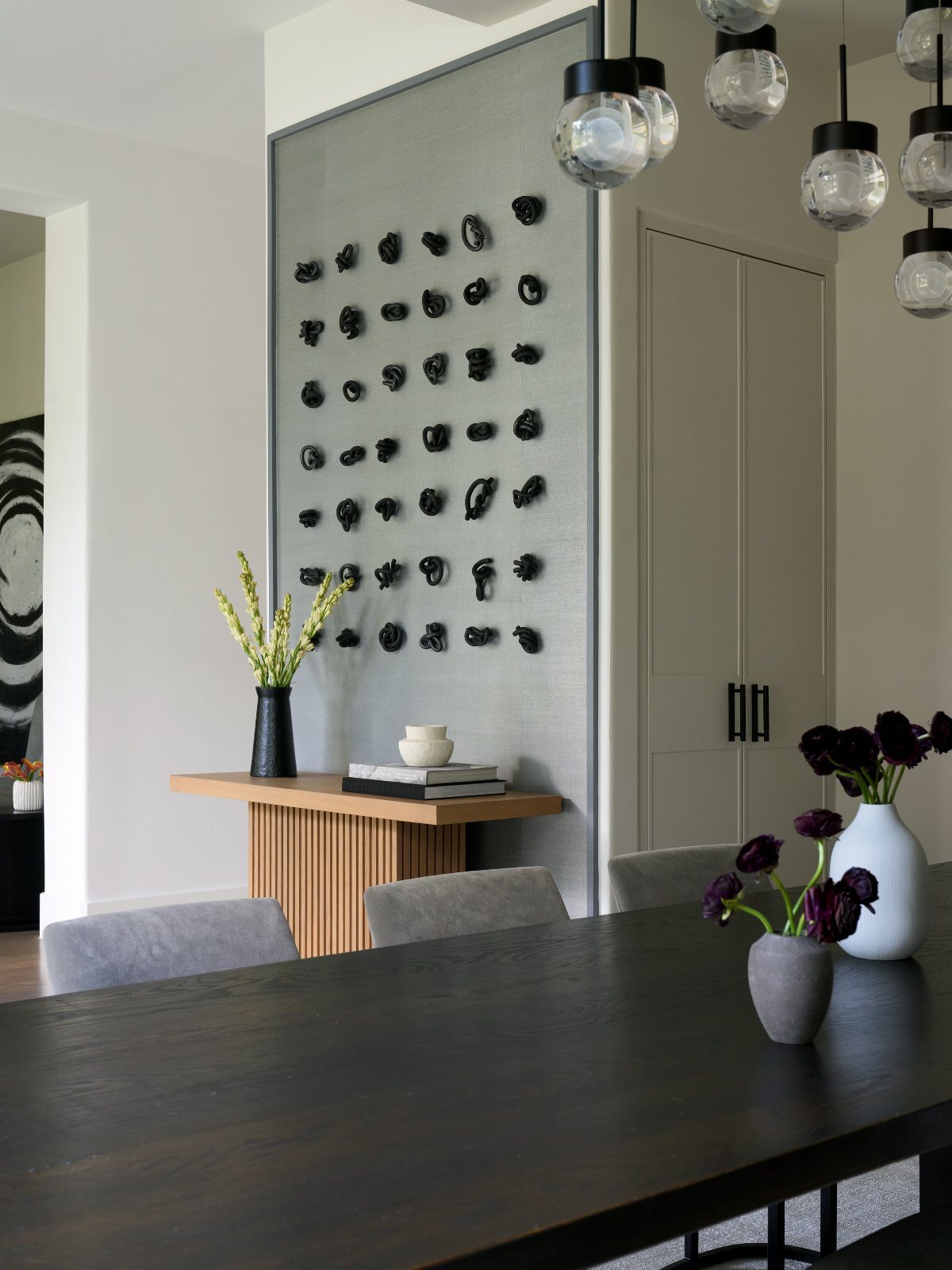 10 Dining Room Grey Wall Ideas for a Refined Look 10 Modern dining room with a dark wood table and grey accent wall art.