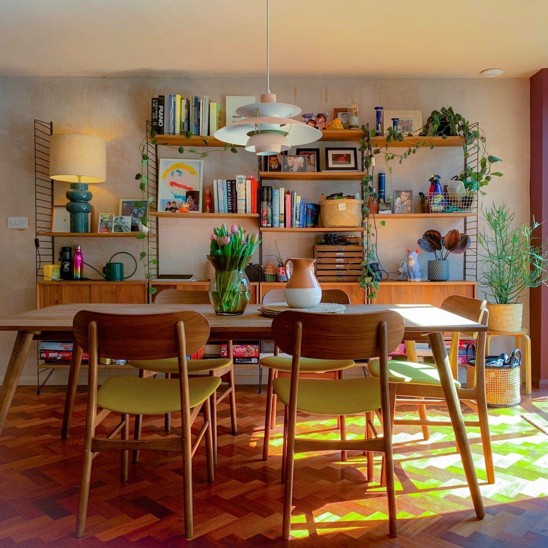 Dining Room Mid Century Ideas: 6 Ways to Style Your Space 5 Mid-century modern dining room with wooden furniture, green chairs, and a bookshelf wall.
