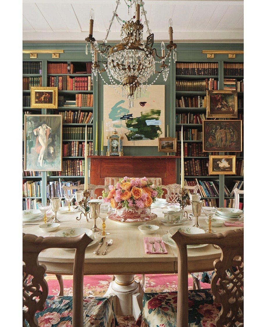 Formal dining room with a set table and large built-in bookshelves displaying art.