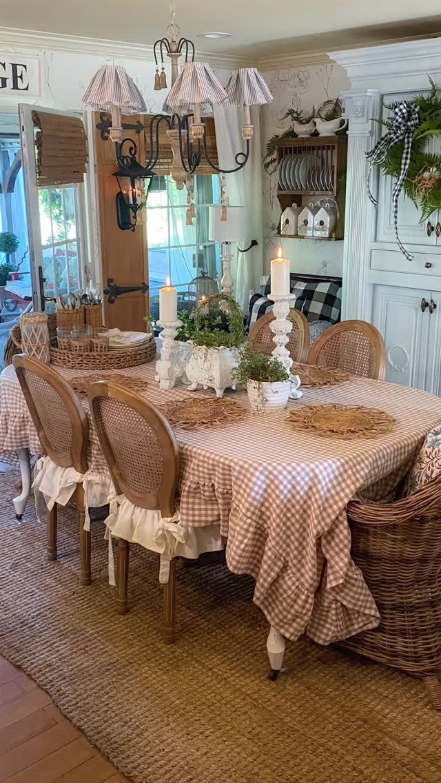 Vintage white candlesticks and greenery on a checkered dining room table.